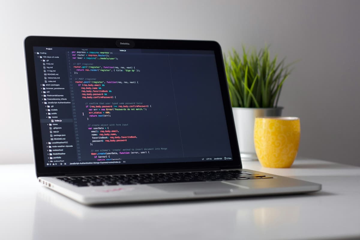 Close-up of a React developer writing JavaScript on a laptop with a code editor open