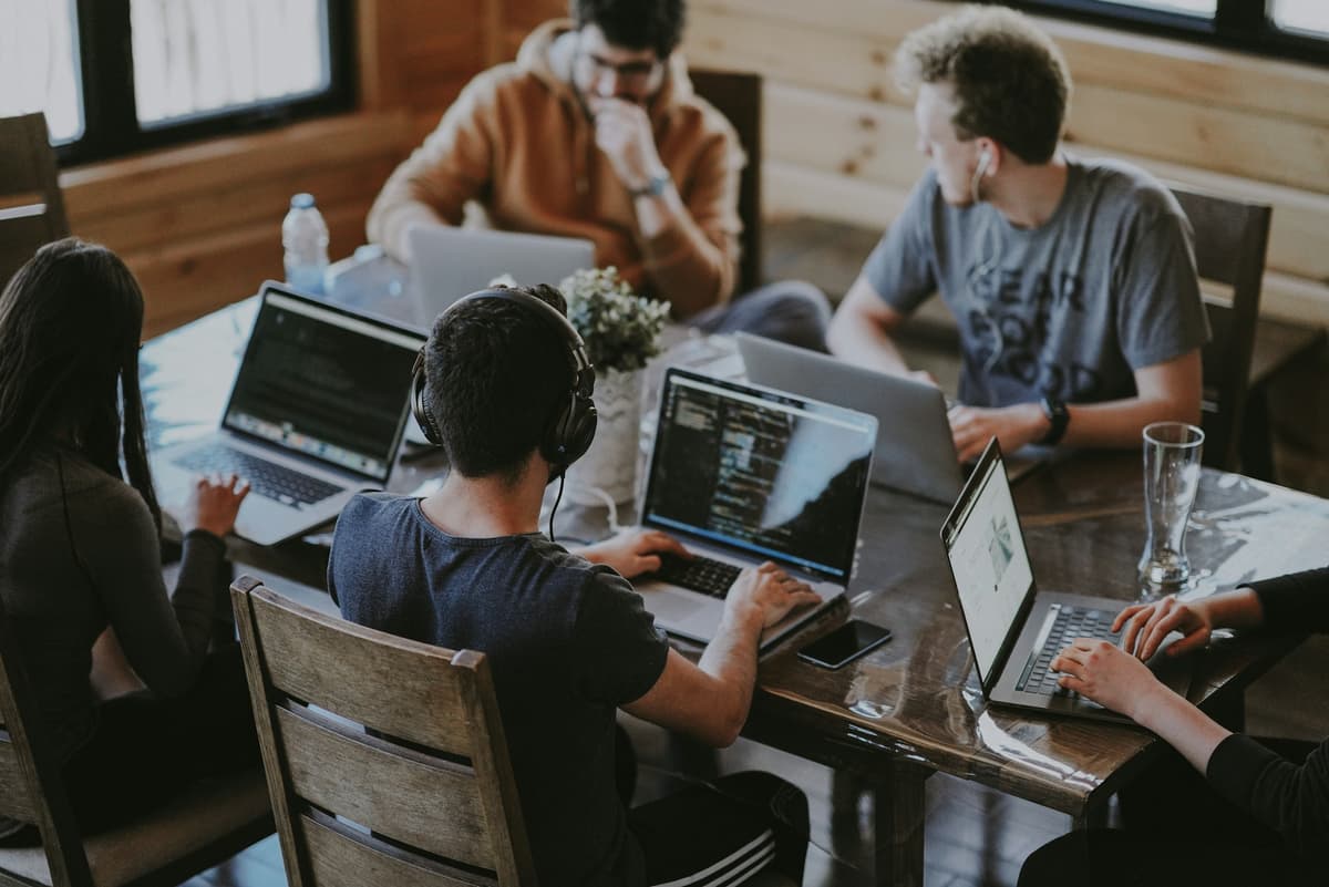 Indian product and engineering team collaborating around laptops in a modern office
